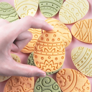 Stampo per biscotti 3D uovo di Pasqua con motivi a rilievo su biscotti arancio e verdi