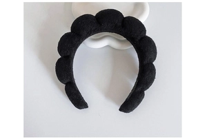 Detailed top view of a black plush cloud sponge headband on a clean white backdrop