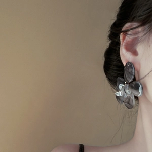 Resin flower earrings with grey marble pattern shown on a model in a side profile view