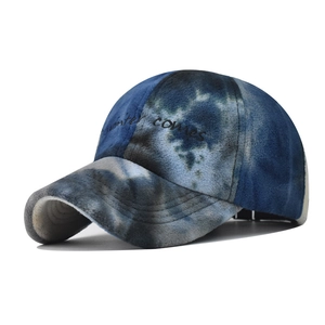 Detailed view of winter comes embroidery on tie-dye fleece baseball cap texture