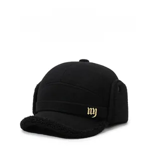 Detail of warm black wool baseball cap featuring thick ear flaps and golden logo
