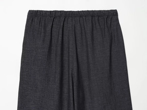 Détail de la taille élastique d'un pantalon gris foncé montrant la texture du tissu