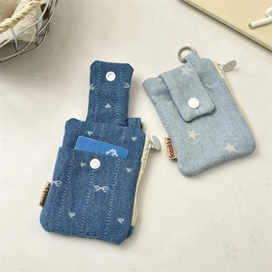 Detail of denim card holders with bow embroidery and star patterns with metal D-rings