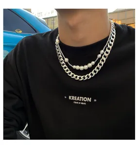 Gros plan d'un collier double rang avec chaîne cubaine argentée et perles