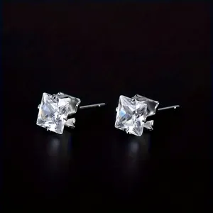 Close-up of square-cut cubic zirconia earrings with a classic four-prong silver setting