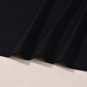 Dettaglio del tessuto in maglia nera con robusta doppia cucitura sull'orlo del vestito