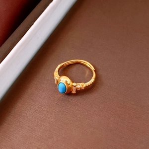 Macro detail of vintage gold ring with oval blue turquoise and sparkling zircon accents