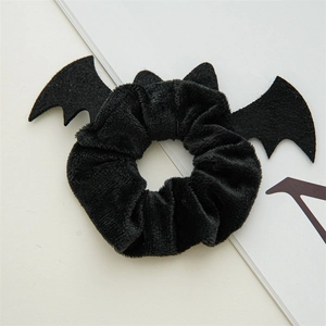 Detail of a black velvet scrunchie featuring spooky bat wing and ear designs