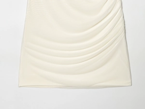 Detail shot of white mesh patchwork dress with elegant pleated fabric texture
