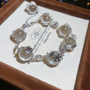 Detailed view of crystal beaded snowflake bracelet on a premium brown velvet jewelry box