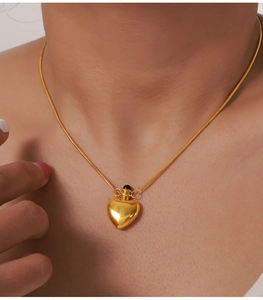 Close-up of heart-shaped gold pendant necklace worn on neck with polished metal finish