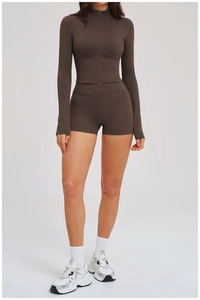 Detail of dark coffee slim-fit yoga set with zip-up jacket and high-waist shorts pockets