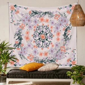 Detail of purple and orange floral mandala tapestry hanging in a cozy home setting