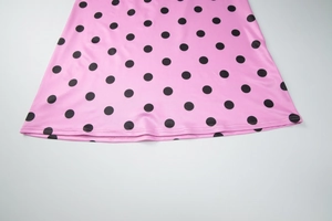 Gros plan détaillé de l'ourlet de la robe rose à pois avec texture de tissu lisse