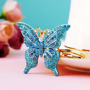 Macro shot of blue gradient crystal butterfly keychain on a delicate floral background