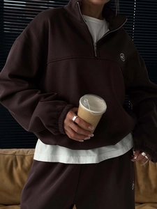 Detail of dark brown quarter-zip fleece hoodie and joggers set with embroidery