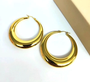 Detailed macro view of 18K gold plated hollow crescent hoop earrings on white backdrop