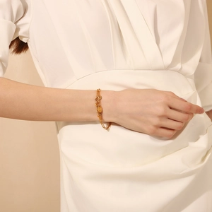 Detail of 18K gold double layer chain bracelet with coin pendant on model wrist