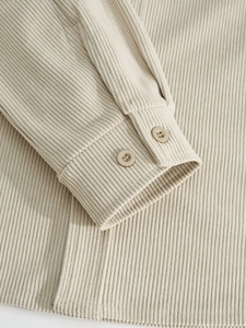 Detailed view of corduroy jacket cuff featuring vertical texture and resin buttons