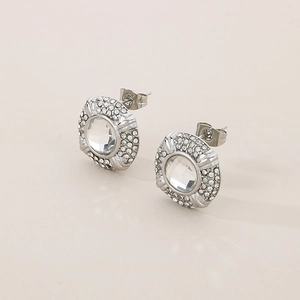 Close-up of silver-tone oval stud earrings with clear gemstone and halo diamond accents