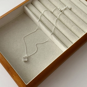 Detail of 18k gold plated hollow square pendant necklace inside a luxury wooden jewelry box