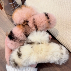 Detailed close-up of soft plush leopard print faux fur hair claws in warm tones