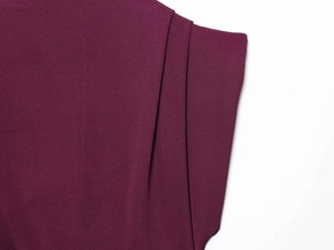 Detailed close-up of dark purple pleated fabric with premium fine texture and drapery