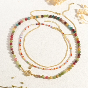 Macro shot of layered colorful gemstone beads with a gold star pendant and chain