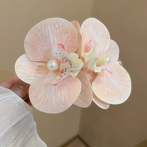 Detail of gradient pink fabric orchid petals and pearls on a sweet floral hair clip