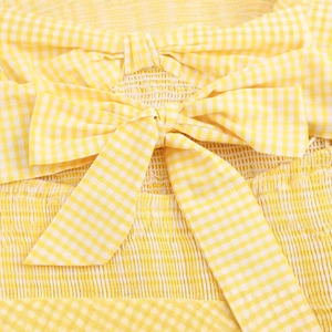 Yellow and white gingham dress featuring a decorative bow and elastic smocked details