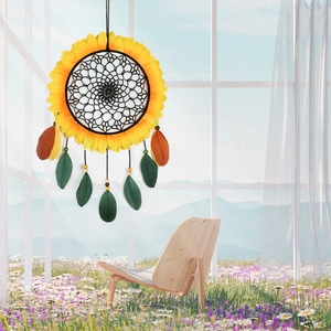 Sunflower dream catcher with yellow petals and brown feathers hanging near a window