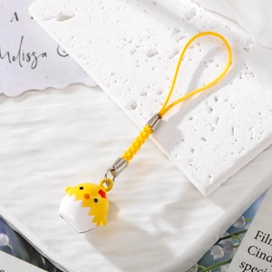 Detailed view of a yellow chick bell pendant with a bright woven strap and lanyard