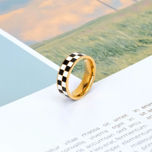 Classic golden checkerboard ring featuring black and white enamel pattern on a white base