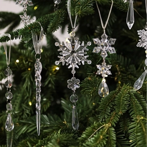 Macro shot of transparent crystal icicle and snowflake ornaments hanging on a Christmas tree