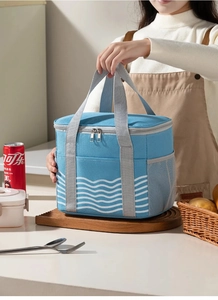 Detail of blue wave pattern insulated lunch bag with mesh side pocket and nylon handle
