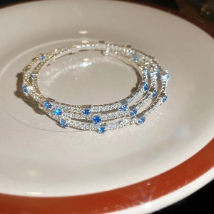 Macro shot of triple-layer silver bracelet with white zircons and deep blue rectangle stones