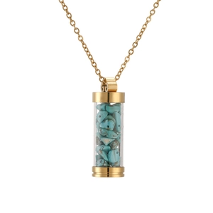 Close-up of golden perfume bottle necklace pendant filled with turquoise stones