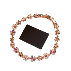 Rose gold flower bracelet with pearls and purple zircons on a white background