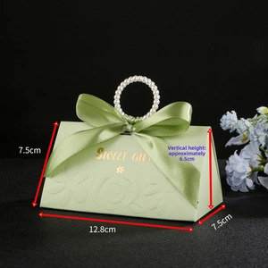 Detail of green triangular gift box with white pearl handle and golden Sweet Gift text