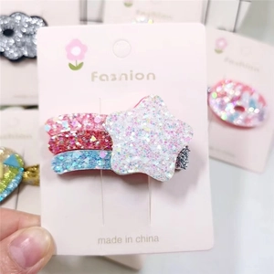 Detail of glitter star hair clip with rainbow sequins on decorative display card