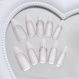 Handmade pink cat eye press-on nails in long almond shape with French white tips and pearls