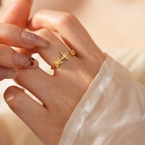 Nahaufnahme eines Vintage Goldrings mit Zirkonia-Blumen auf der Hand eines Models