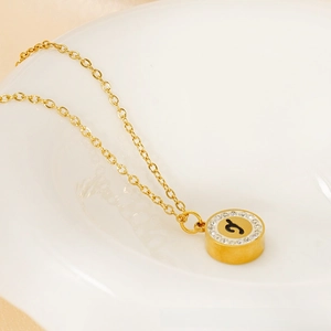Detail of gold letter J pendant with micro-pave crystals on 18K stainless steel chain