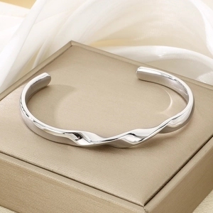 Macro shot of silver wave-pattern twisted cuff bracelet on a premium jewelry box