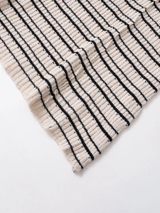 Nahaufnahme des schwarz-weiß gestreiften Rippstrickgewebes eines Midi-Kleides