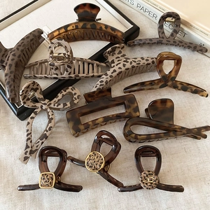 Detail of leopard print hair clips and acetate claw clips on a vintage magazine tray