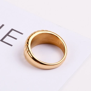Macro detail of golden croissant textured ring featuring bold radial grooves on the wide band