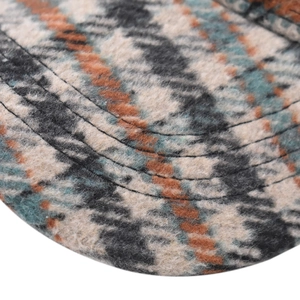 Close-up of thick houndstooth plaid fabric and reinforced stitching on baseball cap
