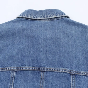 Detailed view of denim mini dress collar and back stitching on blue cotton fabric
