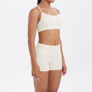 Vue latérale de l'ensemble de yoga crème avec brassière et short taille haute